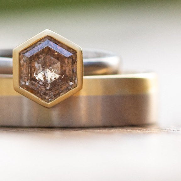 18k gold rings with hexagonal diamond on a light background
